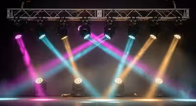 Luminarias LED montadas en truss de escenario proyectando haces de colores