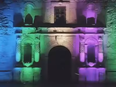 Portada colonial iluminada con uplighting en azul y morado