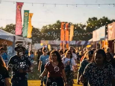 Burbujas flotando sobre los asistentes de un evento al aire libre de día