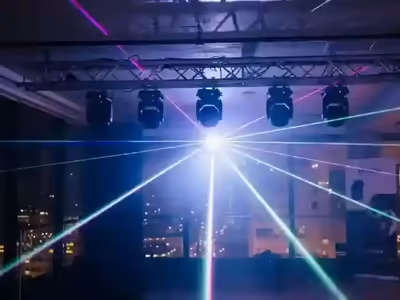 Equipos de láser montados en truss proyectando haces sobre el salón