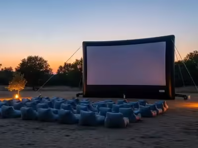 Pantalla inflable montada en un jardín al atardecer con asientos alineados