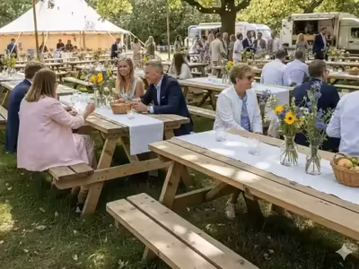 Mesas picnic con mantel y centro de mesa en un evento de jardín