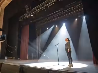 Dos seguidores de luz iluminando a una presentadora en el escenario